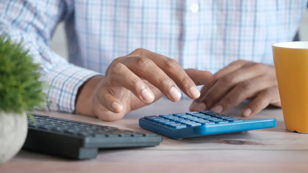 Someone working out figures on a calculator at a desk